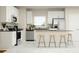 Modern kitchen with sleek, stainless-steel appliances, white cabinetry, gray countertops and a convenient center island with seating at 2899 Transformation Way, Clermont, FL 34714