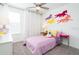 A bright, comfortable bedroom with colorful horse decor, soft carpet, and window with curtains at 3001 Namaste Dr, Clermont, FL 34714
