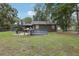 Spacious backyard showcases green lawn, a house with a screened-in porch, and a covered outbuilding at 3807 Timberlake N Rd, Lakeland, FL 33810