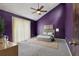 Staged bedroom featuring purple walls, a ceiling fan, carpeted floors, and a large window at 3807 Timberlake N Rd, Lakeland, FL 33810