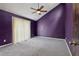 Bedroom featuring purple walls, a ceiling fan, carpeted floors, and a large window at 3807 Timberlake N Rd, Lakeland, FL 33810