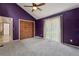 Bedroom featuring purple walls, a ceiling fan, carpeted floors, closet, and a large window at 3807 Timberlake N Rd, Lakeland, FL 33810
