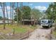 Well-maintained exterior with gravel driveway, RV parking, and partially fenced yard at 3807 Timberlake N Rd, Lakeland, FL 33810