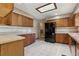Traditional-style kitchen featuring wood cabinetry, neutral countertops, tile backsplash, and a bright skylight at 3807 Timberlake N Rd, Lakeland, FL 33810