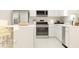 Modern kitchen featuring white cabinets, stainless steel appliances, and a convenient breakfast bar at 442 Puma Loop, Groveland, FL 34736