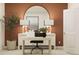 Comfortable home office with desk, chair, large mirror, modern lighting and an accent wall at 442 Puma Loop, Groveland, FL 34736