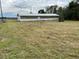 Property view with a white and light brown storage structure in a grassy setting at 149 County Road 640, Lake Wales, FL 33859