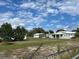Spacious property featuring a charming light blue home with a white roof, green trees, and expansive grounds at 149 County Road 640, Lake Wales, FL 33859