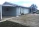 Home exterior with carport, concrete patio, and screened-in porch under a cloudy blue sky at 149 County Road 640, Lake Wales, FL 33859