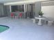Open-air poolside patio featuring a table, benches, and red chairs for relaxing and enjoying the backyard at 149 County Road 640, Lake Wales, FL 33859
