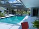 Inviting in-ground pool with a screened enclosure and clear blue water, surrounded by lush landscaping at 149 County Road 640, Lake Wales, FL 33859