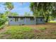 View of the backyard offering a mix of lawn space and mature trees for a natural setting at 1727 Bonita Ave, Orlando, FL 32805