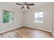 Bedroom featuring two windows, stylish wood-look flooring, and ample natural light at 1727 Bonita Ave, Orlando, FL 32805