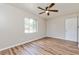 Bright bedroom with wood floors, a ceiling fan, and a large window for natural light at 1727 Bonita Ave, Orlando, FL 32805