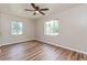 Inviting bedroom featuring wood floors, natural light from windows, and a modern ceiling fan at 1727 Bonita Ave, Orlando, FL 32805