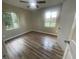 Inviting bedroom featuring new floors, fresh paint, and two large windows overlooking the yard at 1727 Bonita Ave, Orlando, FL 32805