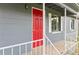 Close-up showcasing a bright red front door, white railings, and neutral-tone siding and trim at 1727 Bonita Ave, Orlando, FL 32805