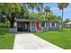 Exterior front view of home featuring mature trees and covered parking with a well manicured yard at 1727 Bonita Ave, Orlando, FL 32805