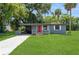 Charming single story home featuring a manicured lawn, a carport and a bright red front door at 1727 Bonita Ave, Orlando, FL 32805
