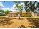 Rear exterior view with a well-manicured lawn, mature trees, and a tranquil outdoor setting at 2214 Deerbrook Dr, Lakeland, FL 33811