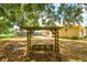 Backyard features a swing, large trees, and lush greenery, creating a serene outdoor space at 2214 Deerbrook Dr, Lakeland, FL 33811