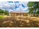 Exterior rear featuring mature trees, a well-maintained lawn, and a peaceful backyard ambiance at 2214 Deerbrook Dr, Lakeland, FL 33811