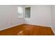 A bright bedroom featuring shiny hardwood floors and natural light from two windows at 2214 Deerbrook Dr, Lakeland, FL 33811