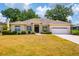 Inviting one-story home with well-manicured landscaping and a two-car garage on a sunny day at 2214 Deerbrook Dr, Lakeland, FL 33811