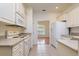 Bright kitchen features white appliances, tiled flooring and ample cabinet storage with a pass-through to a dining area at 2214 Deerbrook Dr, Lakeland, FL 33811
