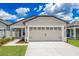 Charming single-Gathering home featuring a two-car garage, manicured lawn, and welcoming front porch on a sunny day at 3832 Corsican Pl, Lake Alfred, FL 33850