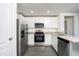Well-equipped kitchen with stainless steel appliances, granite countertops, and white cabinets at 3832 Corsican Pl, Lake Alfred, FL 33850