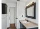 Bathroom featuring a black vanity and framed mirror plus a view into the hallway at 503 Holt Cir, Winter Haven, FL 33880