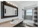 Updated bathroom featuring a shower-tub combo and dark vanity with decorative mirror at 503 Holt Cir, Winter Haven, FL 33880
