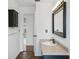 Bathroom with black vanity and framed mirror plus an adjoining hallway and living spaces at 503 Holt Cir, Winter Haven, FL 33880