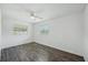 Bedroom with hardwood flooring, ceiling fan, and two windows for natural light at 503 Holt Cir, Winter Haven, FL 33880