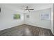 Bright bedroom with three windows, modern dark wood-look floors, and white walls at 503 Holt Cir, Winter Haven, FL 33880