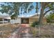 Front exterior of the home with a long driveway, covered carport and partial fence at 503 Holt Cir, Winter Haven, FL 33880