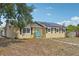 Exterior front view of the home with solar panels, a blue door, and a sidewalk at 503 Holt Cir, Winter Haven, FL 33880