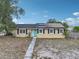 Charming single-story home featuring solar panels, a bright blue front door, and black shutters at 503 Holt Cir, Winter Haven, FL 33880