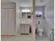 Bathroom features a vanity, toilet, decorative vase, and patterned flooring at 750 Azalea Dr, Bartow, FL 33830