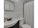 A well-lit bathroom featuring a white toilet, sink, and shower curtain at 750 Azalea Dr, Bartow, FL 33830