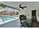 Screened patio area with ceiling fan, dining set and BBQ, offering a comfortable outdoor living space by the pool at 750 Azalea Dr, Bartow, FL 33830