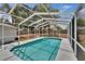 Sparkling in-ground pool surrounded by a screened enclosure and fenced yard provides a private outdoor oasis at 750 Azalea Dr, Bartow, FL 33830