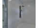 All-white tiled shower with a multi-feature showerhead panel at 750 Azalea Dr, Bartow, FL 33830