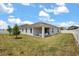 Spacious backyard featuring a covered patio, green lawn, and white fencing at 921 Fieldstone Way, Haines City, FL 33844