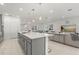 Open concept kitchen features stainless steel appliances, an island with barstool seating, which flows into the living room at 921 Fieldstone Way, Haines City, FL 33844