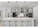 Kitchen boasts a large white quartz island, stainless steel appliances, pendant lighting and gray cabinets at 921 Fieldstone Way, Haines City, FL 33844