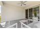 Covered patio features neutral tones, modern furniture, and a ceiling fan for comfortable outdoor living at 921 Fieldstone Way, Haines City, FL 33844