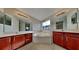 Bathroom with dual sinks, soaking tub, and large mirrors at 3002 Sunscape Ter, Groveland, FL 34736