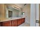 Bathroom with double sinks, spacious countertop, and a large mirror with overhead lighting at 3002 Sunscape Ter, Groveland, FL 34736